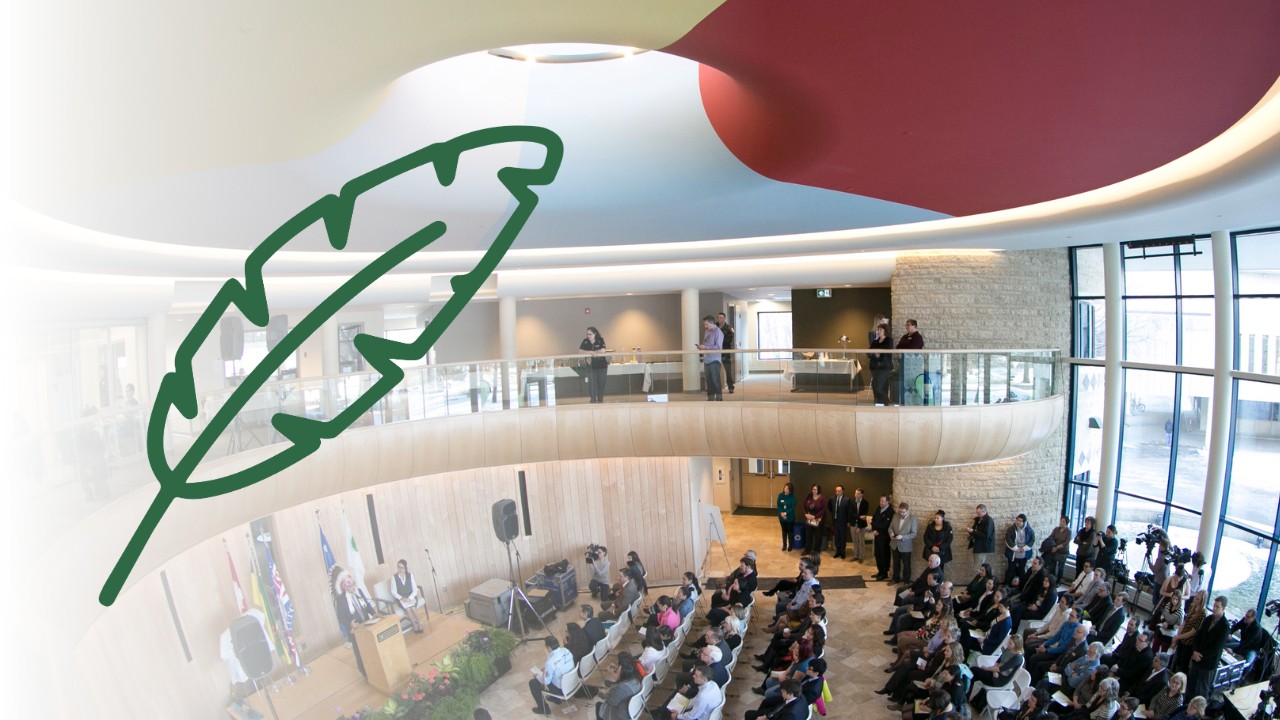 A green illustration of a feather overlays an image of a group in attendance at the University of Saskatchewan's Gordon Oakes Red Bear Student Centre