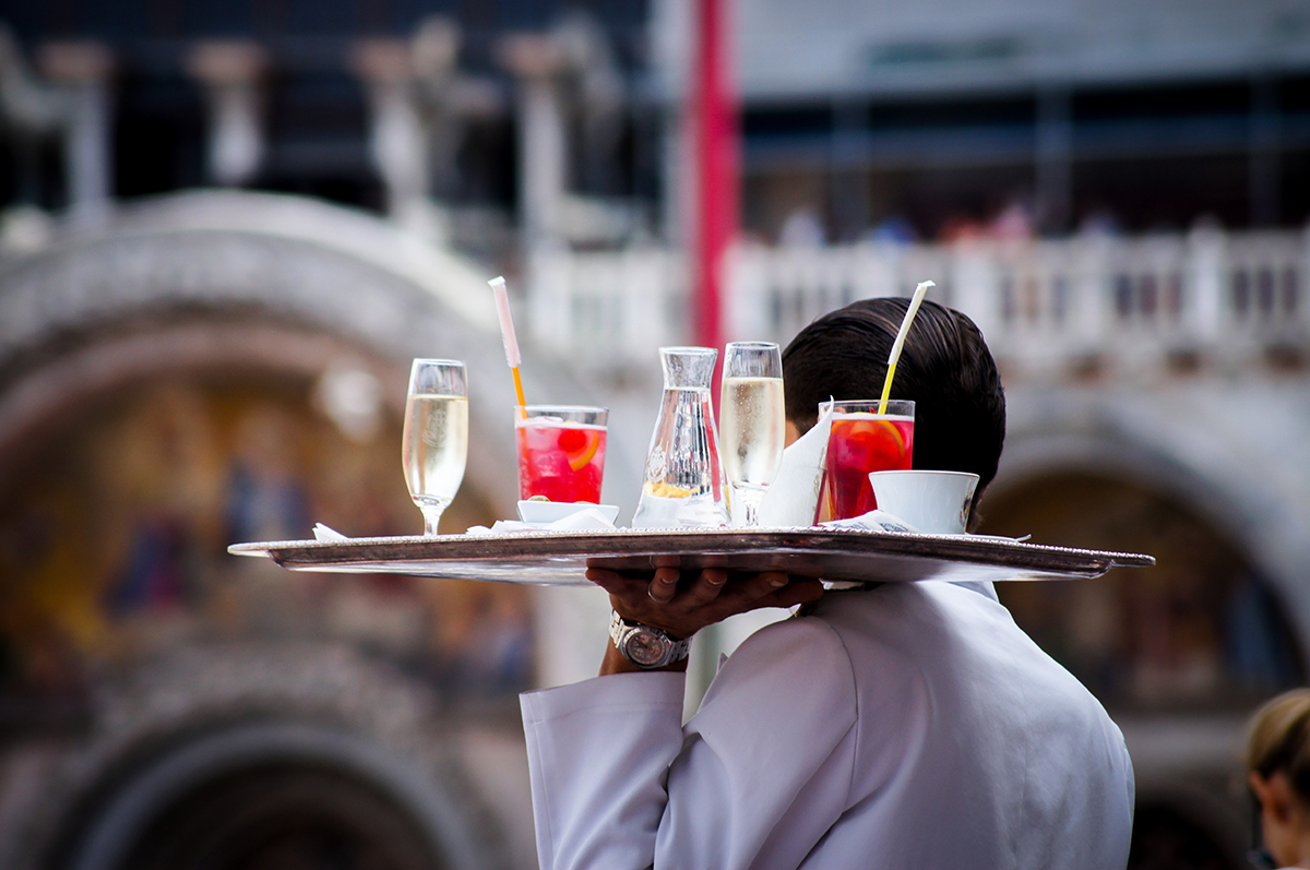 A server carries a tray of drinks.